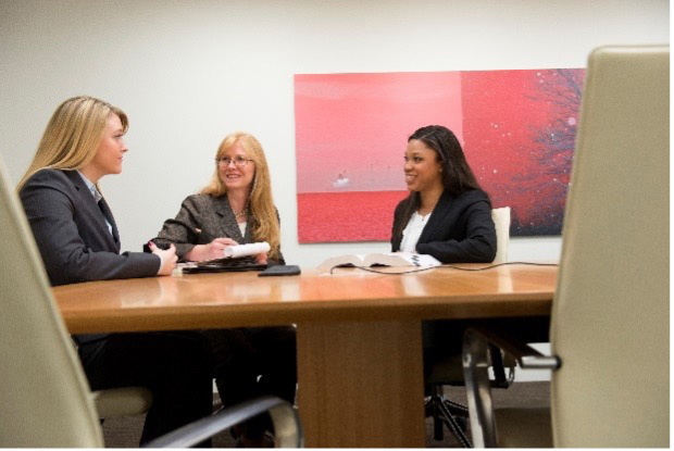 Three women talking at a conference table