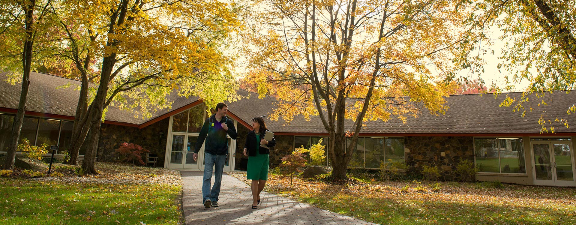Two people walking down a brick path