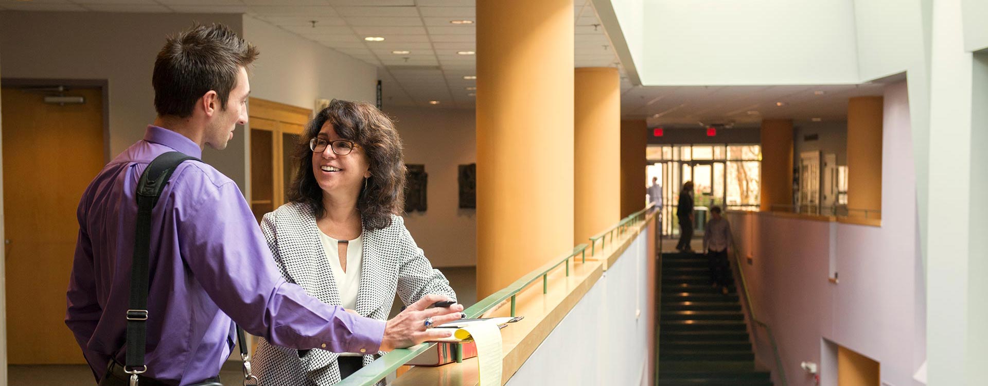 Two people talking in a hallway
