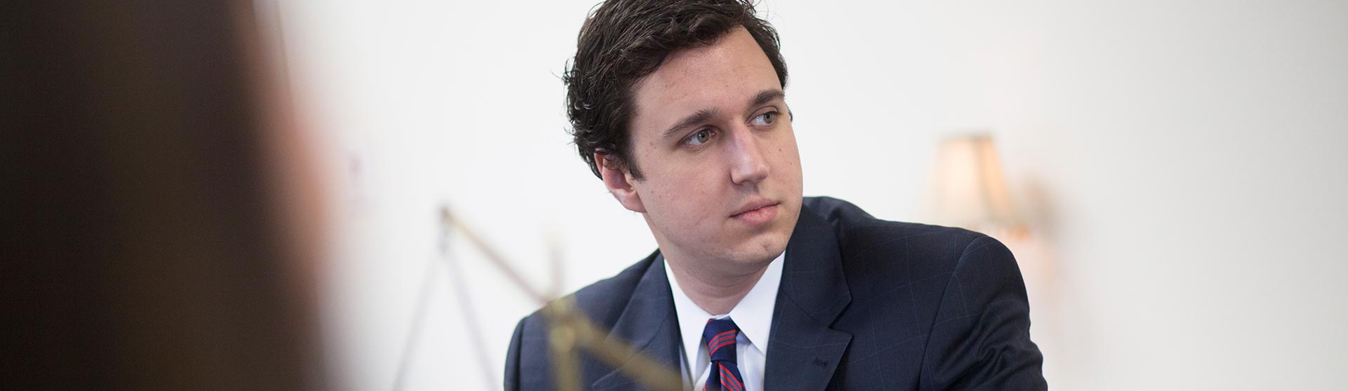 Man wearing a suite and looking off the screen