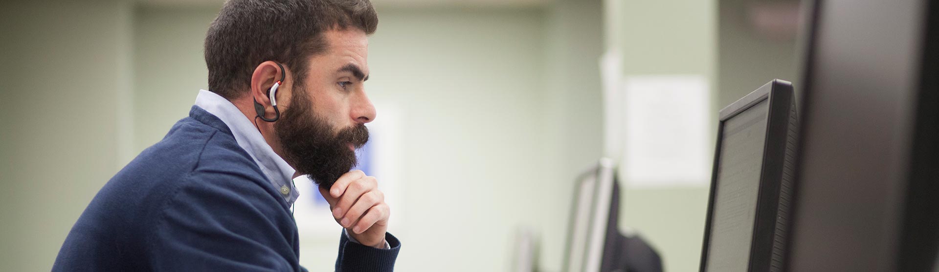 Male student contemplating a computer monitor