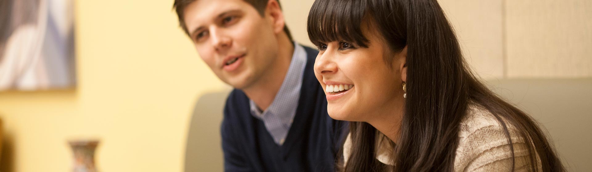 Female student smiling and male student seated next to her